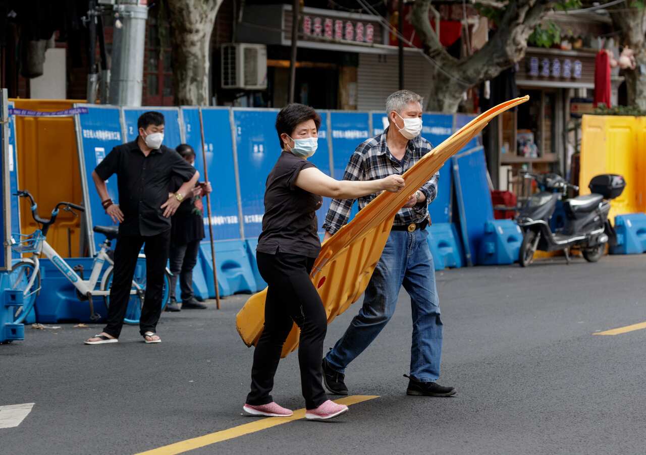 People remove quarantine barricades in front of their homes