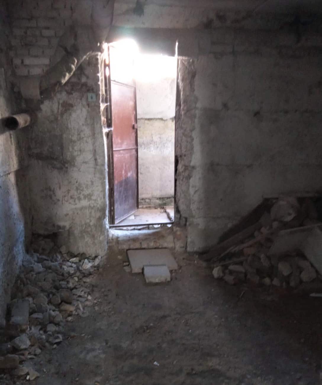 Light shines through the door of a bunker