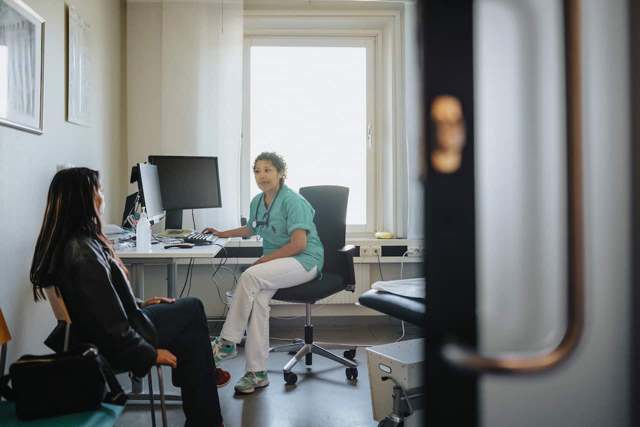 Female physician discussing with a young woman in a doctor's clinic