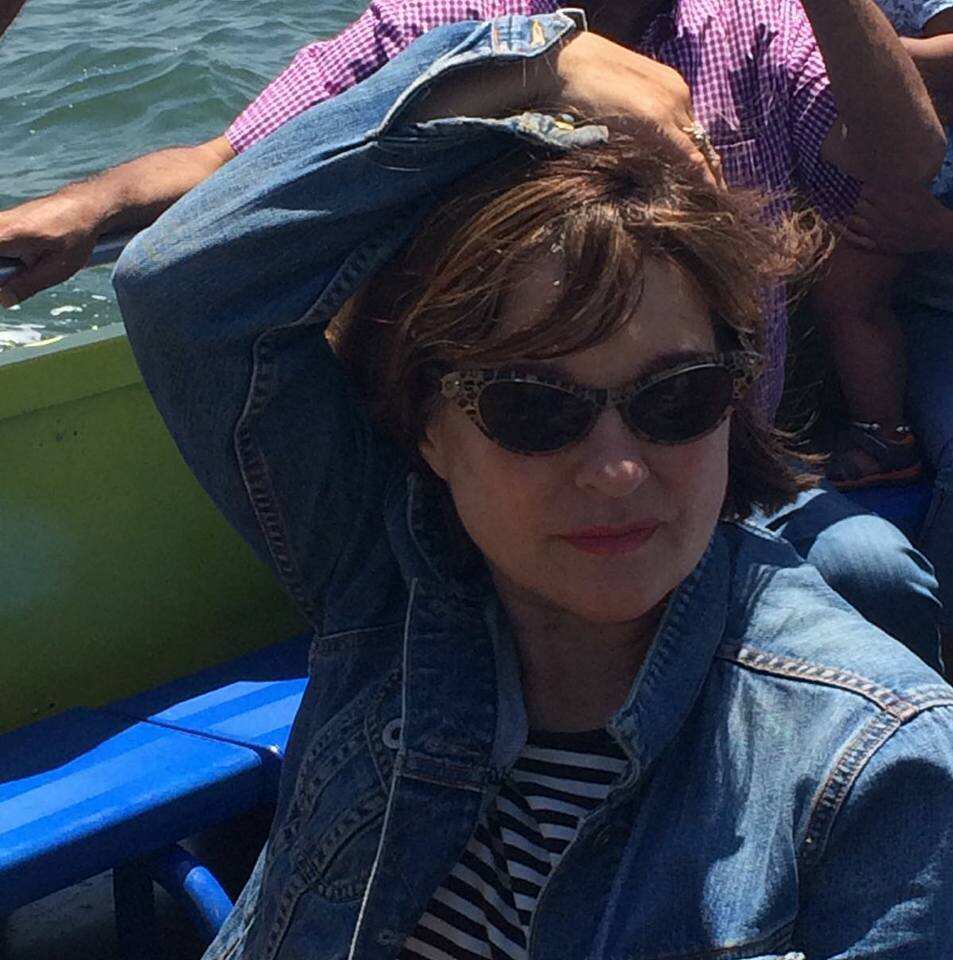 A woman wearing sunglasses and sitting in a small boat