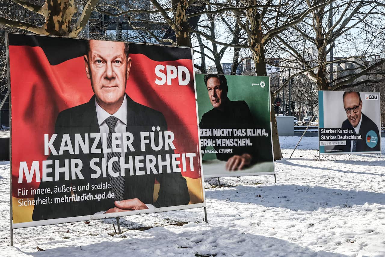 Three election posters with German text, on snowy grass