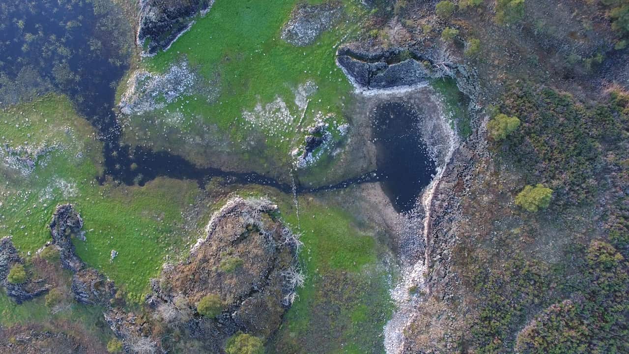 An aerial shot of a water channel and pond