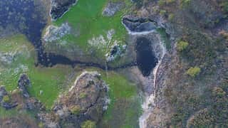 An aerial shot of a water channel and pond