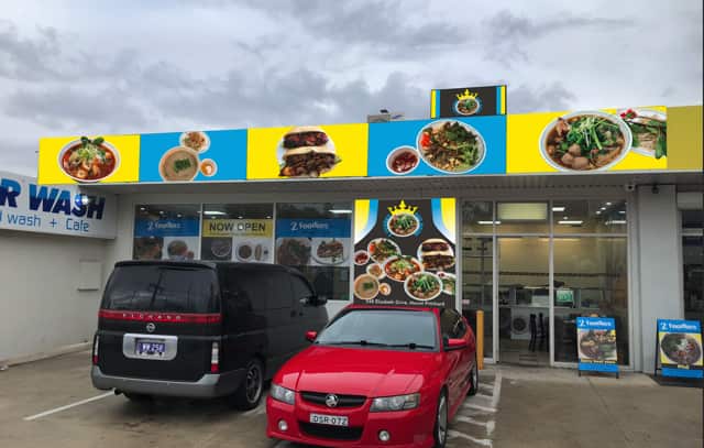 Restaurant with cars parked out the front.