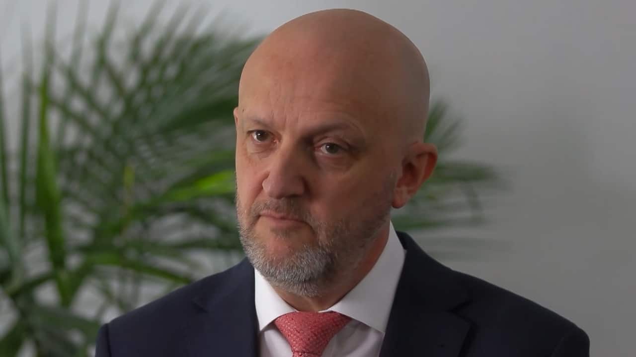 A balding man in a suit and tie