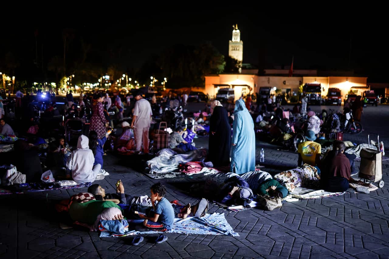 People sleeping outside at night in a large outdoor square