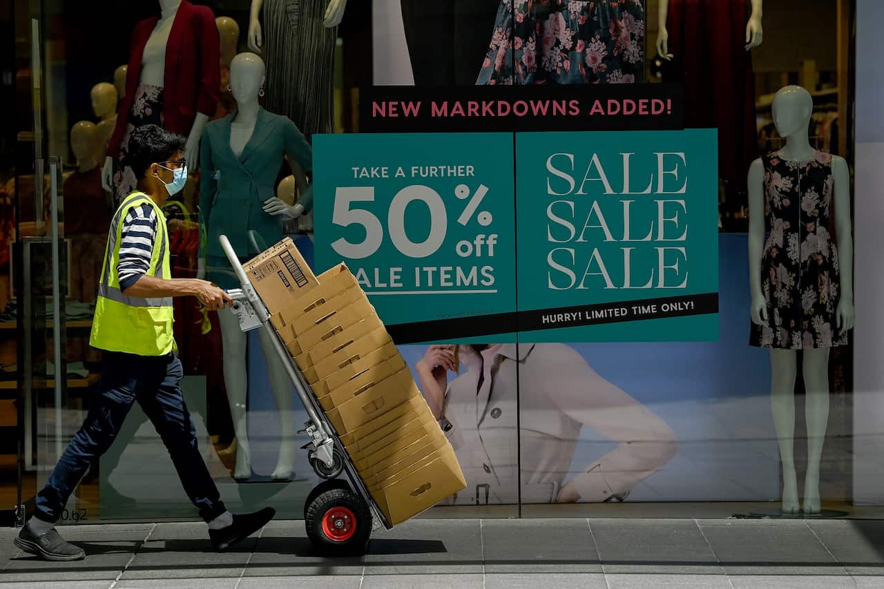 Worker walks past a shopfront