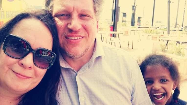 Selfie portrait of a woman, man, and young girl.