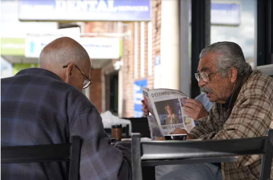 Members of the Greek community in Sydney's inner west often come to cafes to read the newspaper and chat, like George Thanos (right)..png