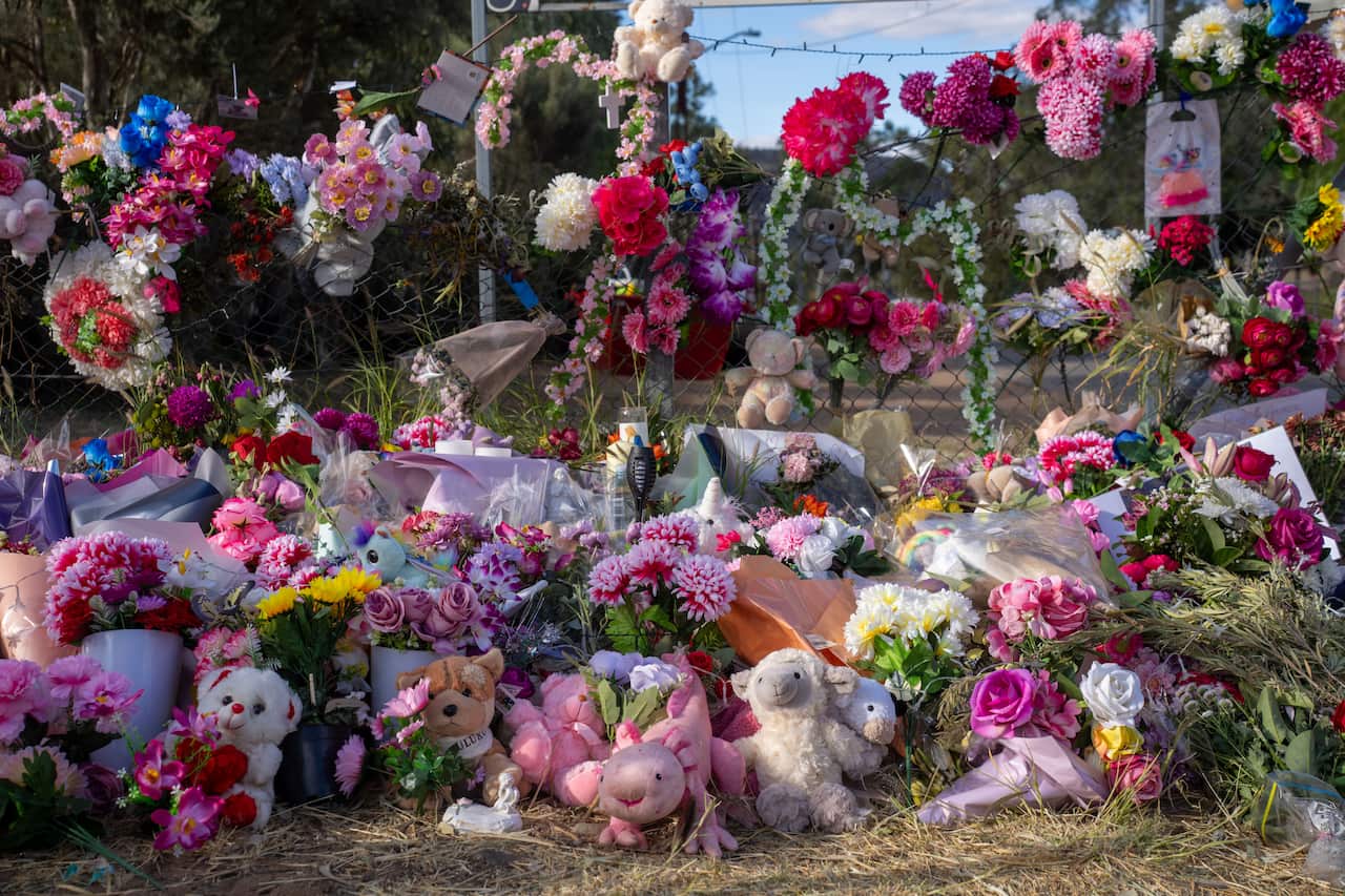 A floral tribute with flower bouquets and children's toys