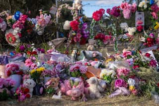 A floral tribute with flower bouquets and children's toys
