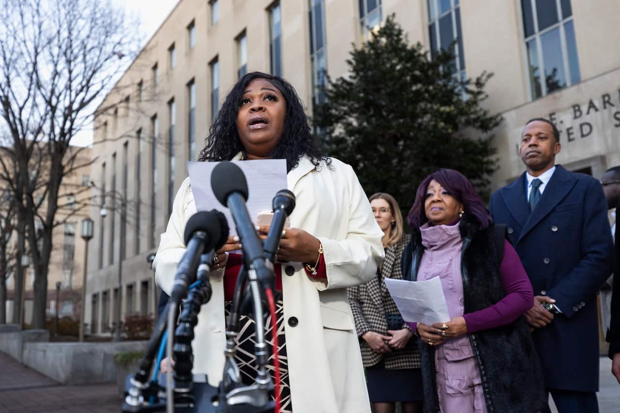 Shaye Moss and Ruby Freeman stand with their legal team outside the court building. 