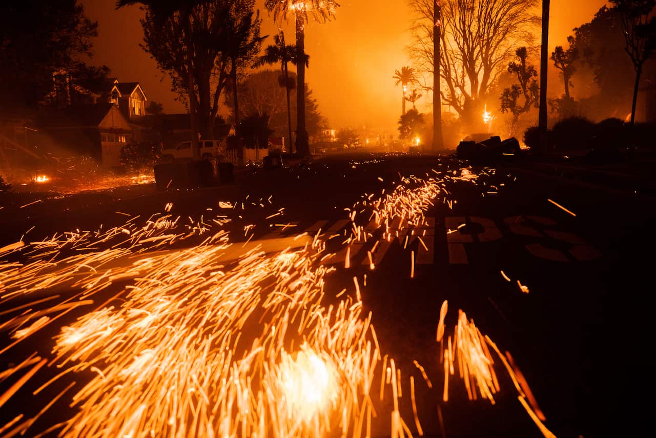 A fire at night sends sparks down a road 