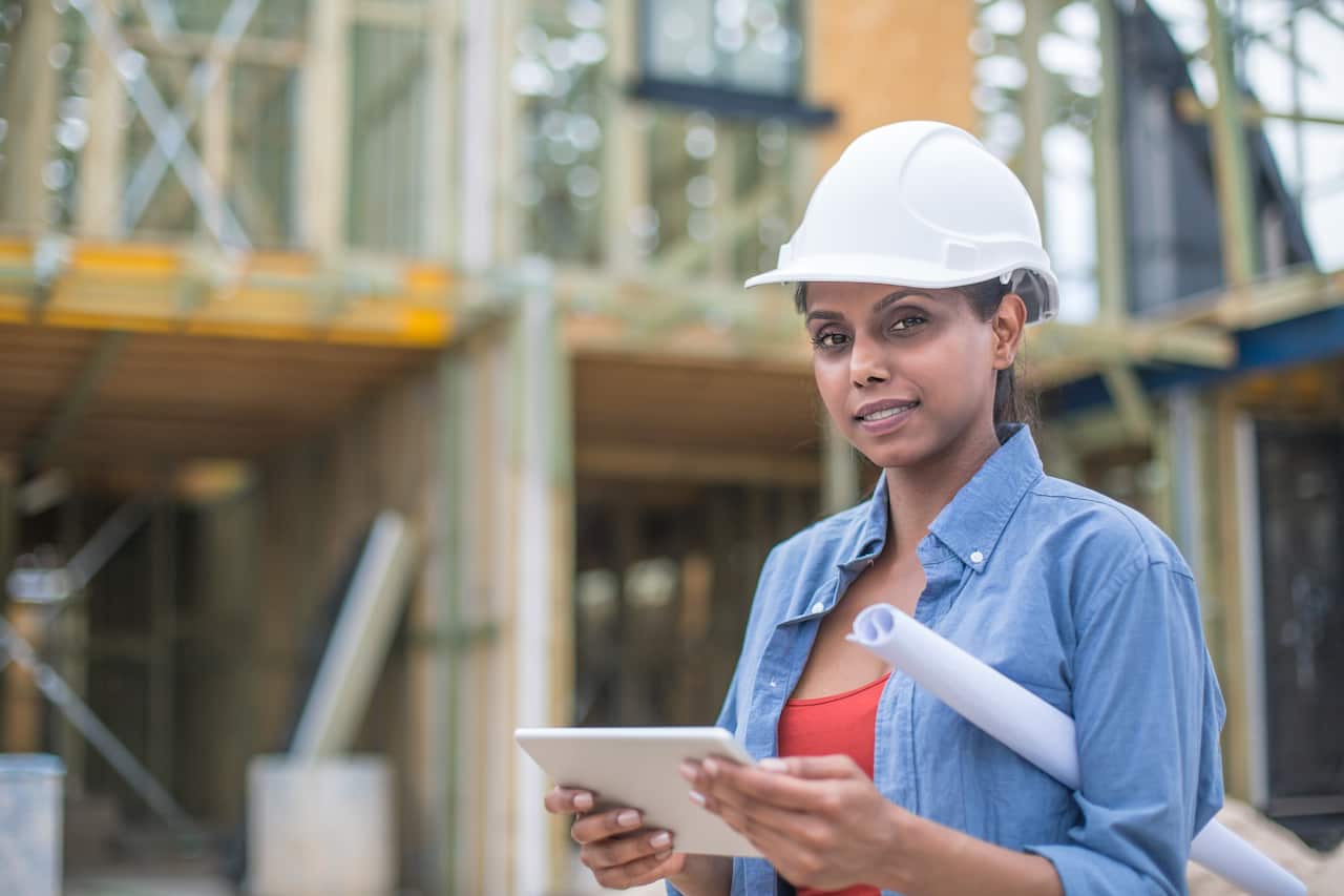 Australian woman Architect with plans on building site