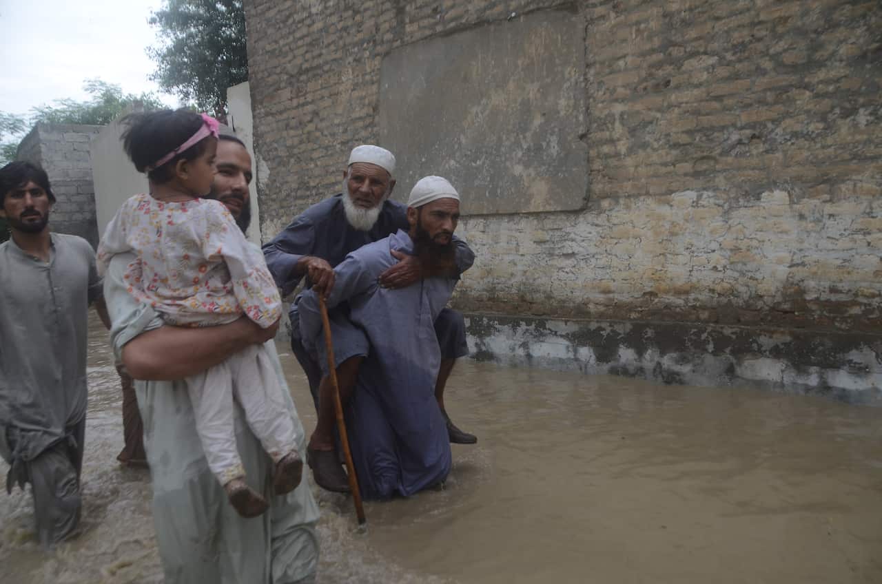 People walk through flooded water