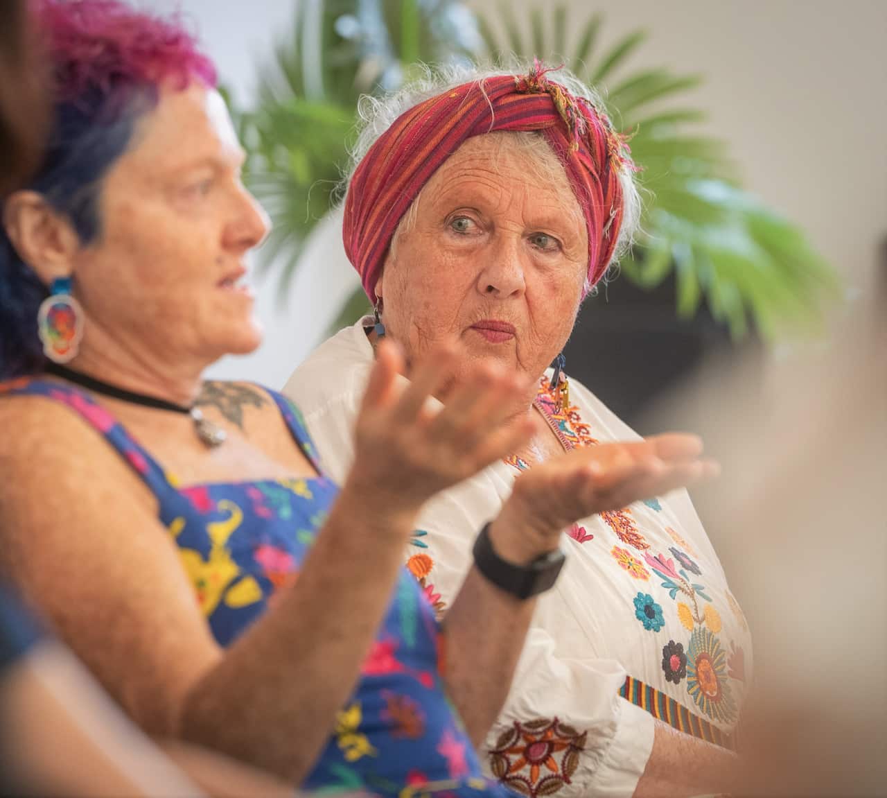 One person speaking while another looks on.