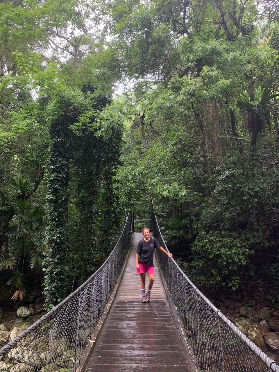 Steph Lentz standing on a suspension bridge in a forest