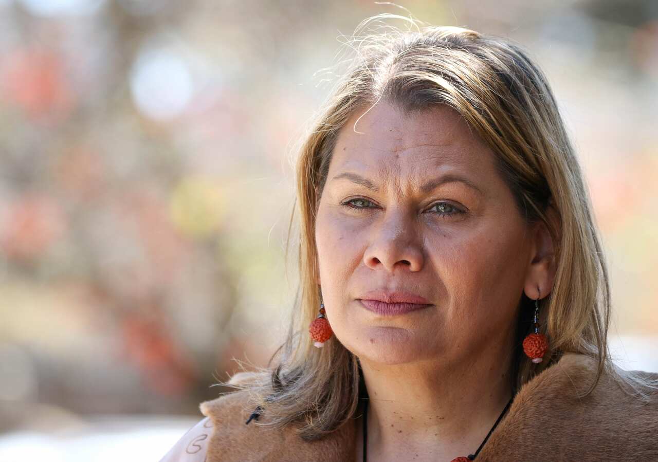 Woman wearing red earrings looks into the distance.