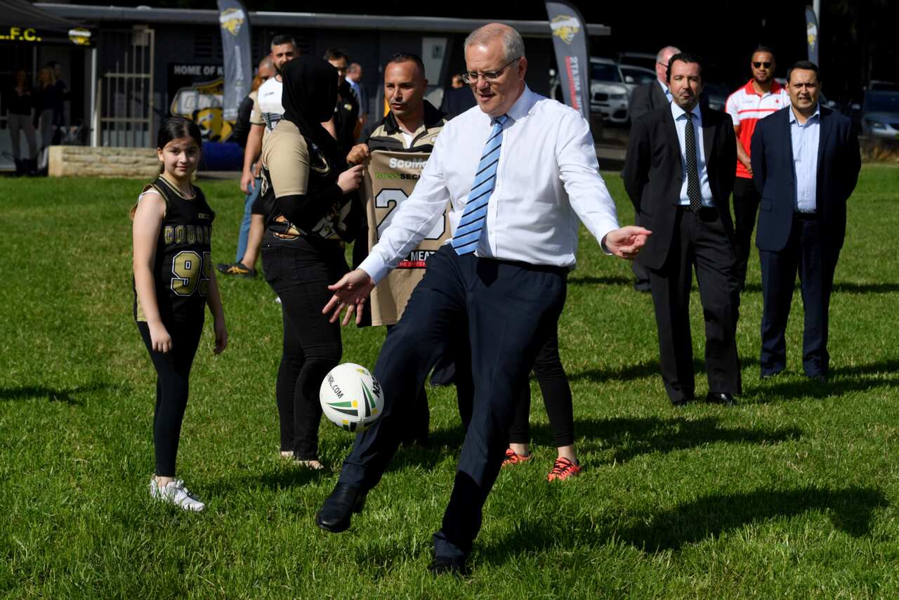 Scott Morrison kicks a football during a visit to his own electorate of Cooke. 