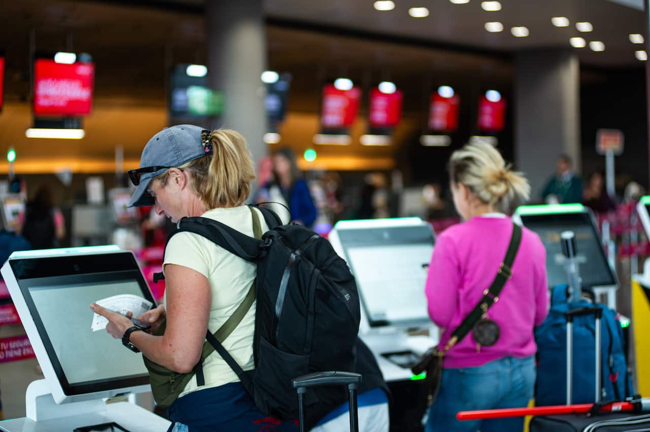 Two women are doing check-in at the airport