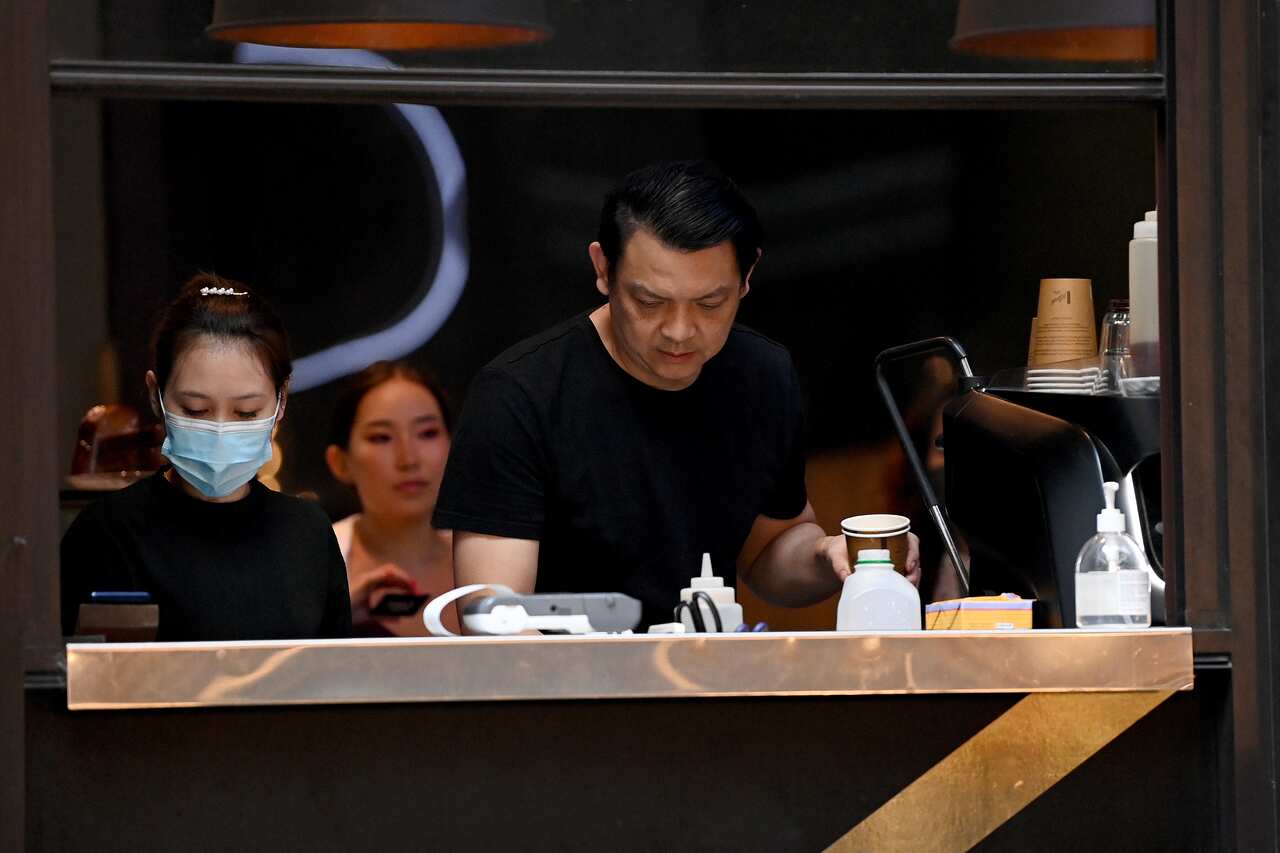 A man and a woman making coffee in a cafe