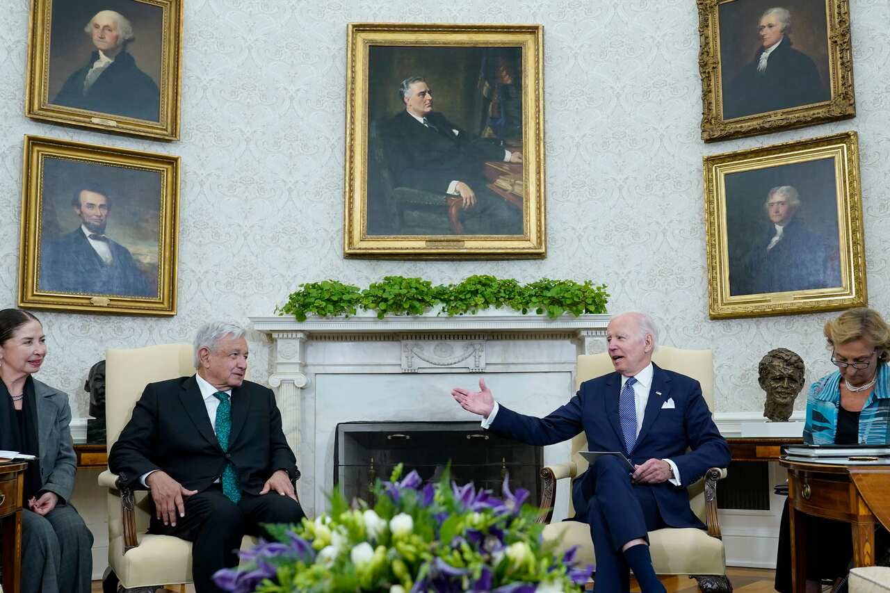 Two men in suits sitting on chairs.