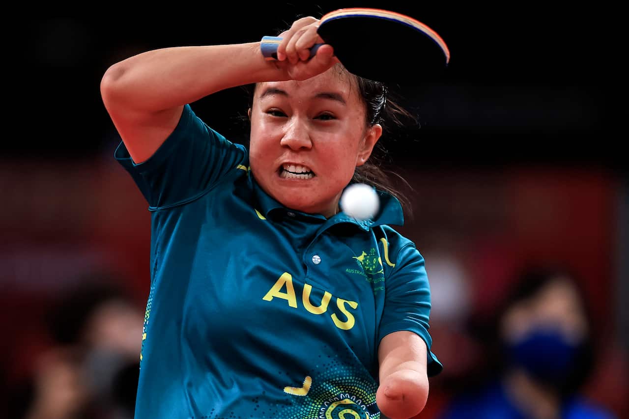 A Paralympian wearing an Australian top while they play table tennis