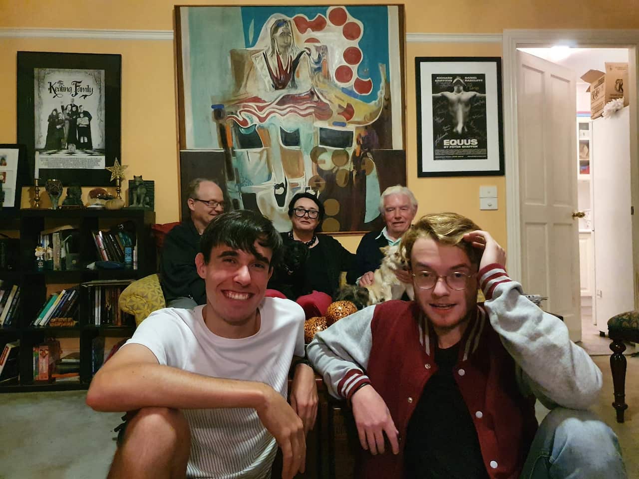 Colette, her two sons, husband and father sitting in the living room. 