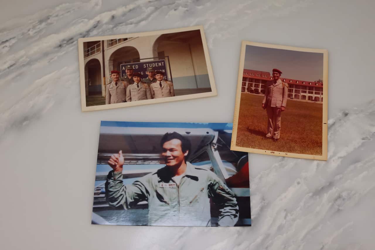 Three old photos of a man in military uniform, laid out on a table.