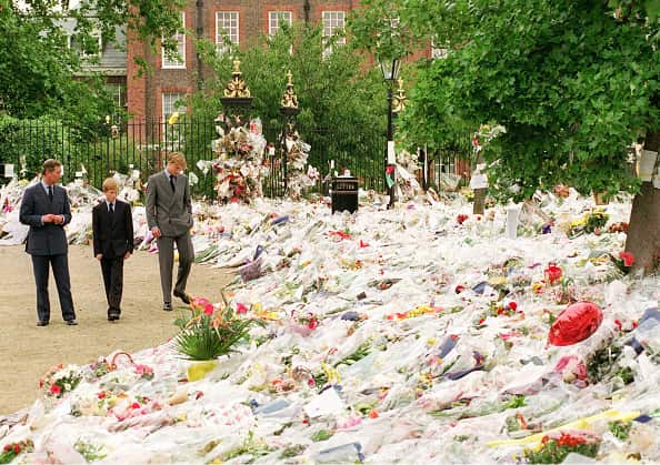 (left to right) Prince Charles, Prince Harry and Prince William examine floral tributes left outside Kensington Palace.