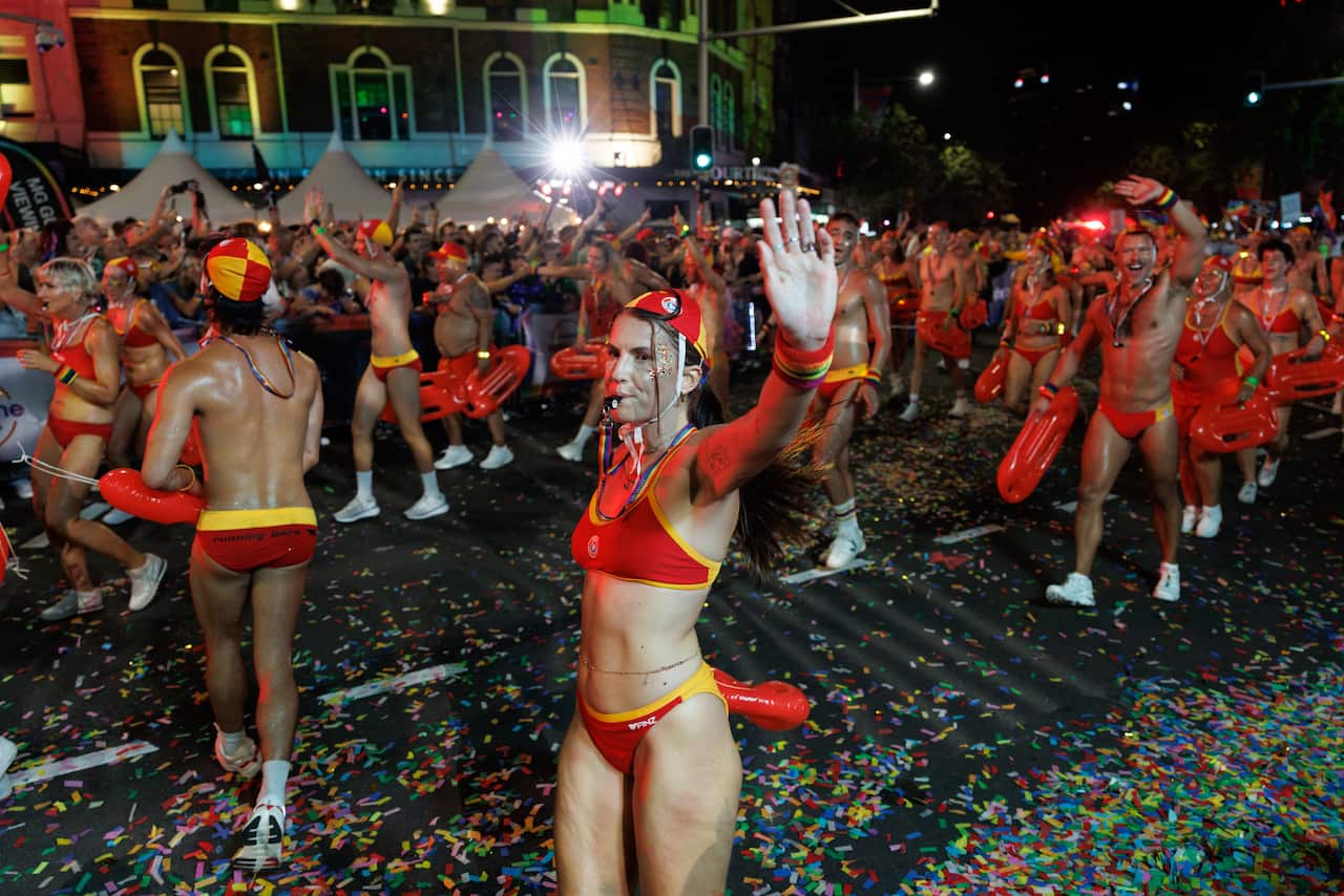 A group of people march in a parade wearing life-saving uniforms.