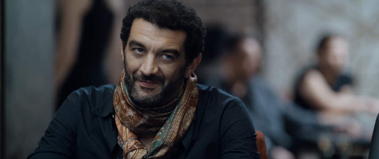 A man sits at a table with a smile on his face