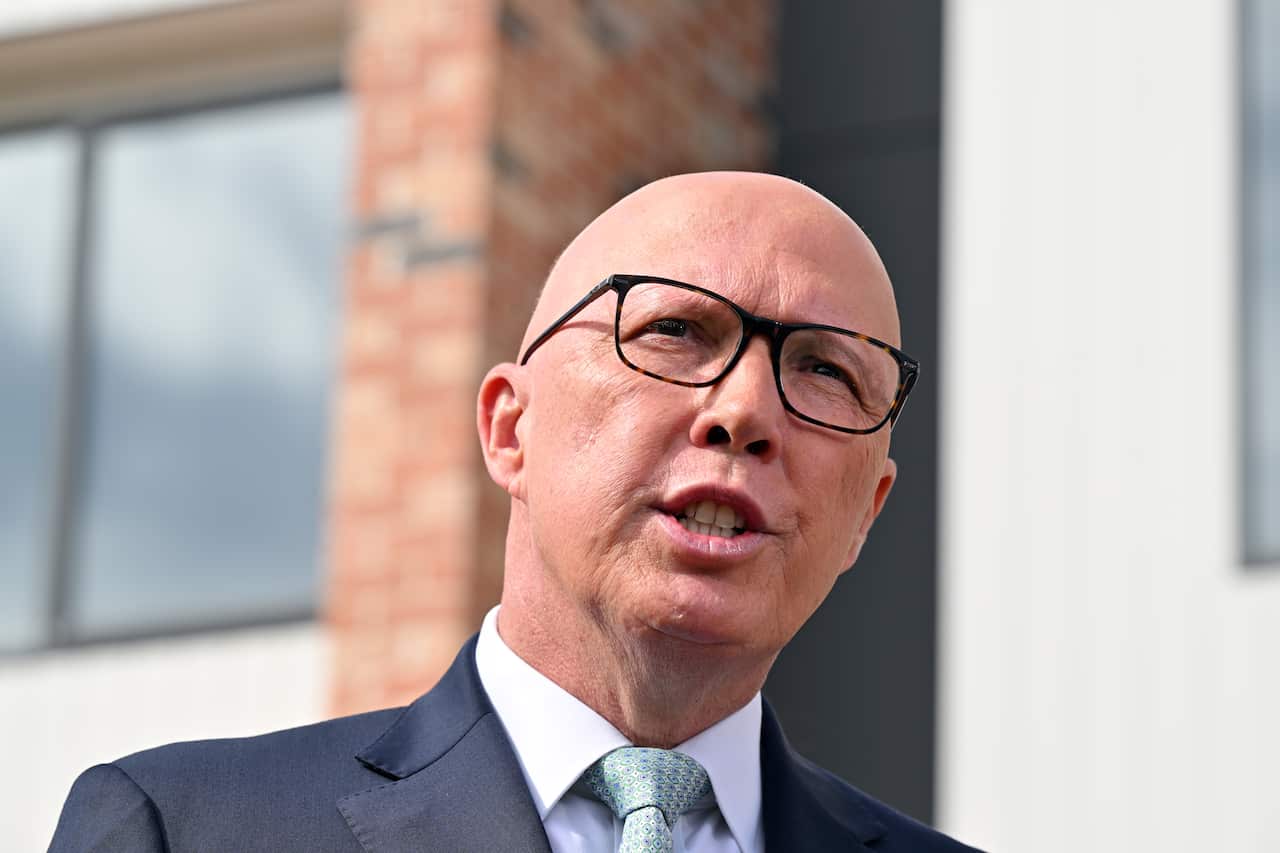 Peter Dutton speaks with a view of a home behind him. 