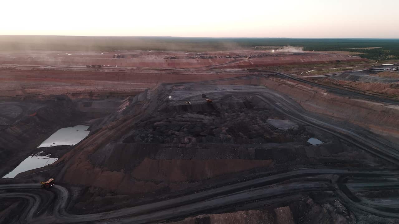 A drone shot of roads winding out of a coal mine pit around sunset.
