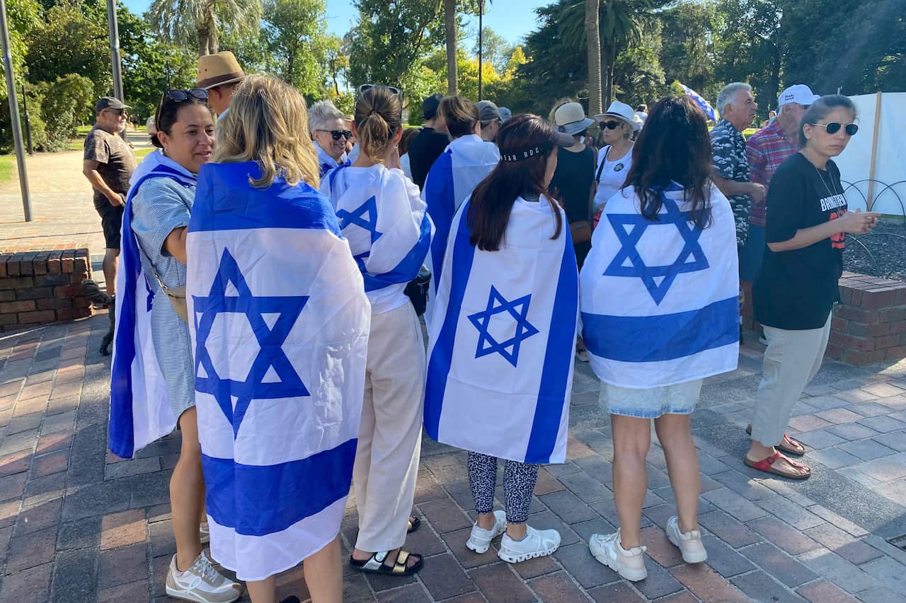 People drape the Israeli flag over their shoulders.