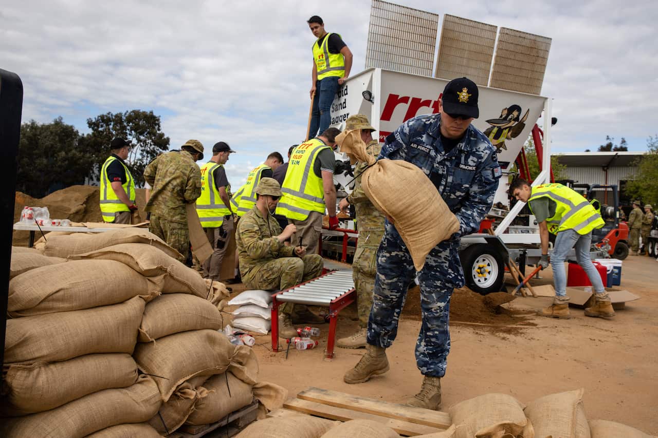 Australian Defence Force personnel prepare sandbags