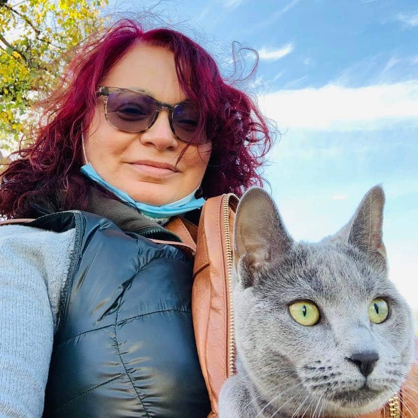 A woman posing for a photo with her cat.