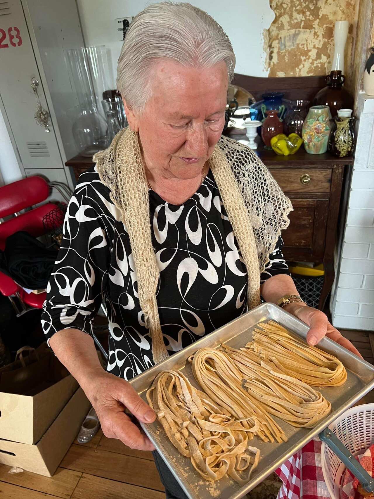 An elderly woman making pasta