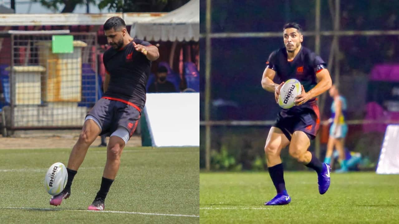 One man kicking a ball and the other running while carrying a ball.