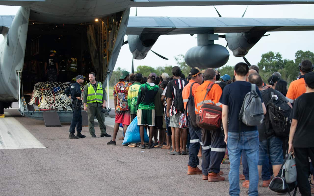 Evacuated people wait to board evacuation flight