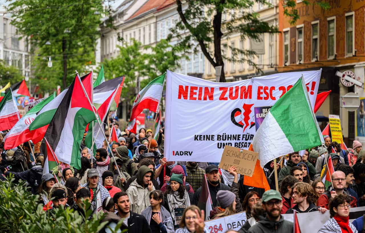 People march on a street holding up flags and signs