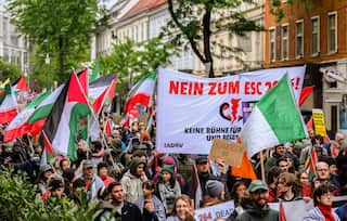 People march on a street holding up flags and signs