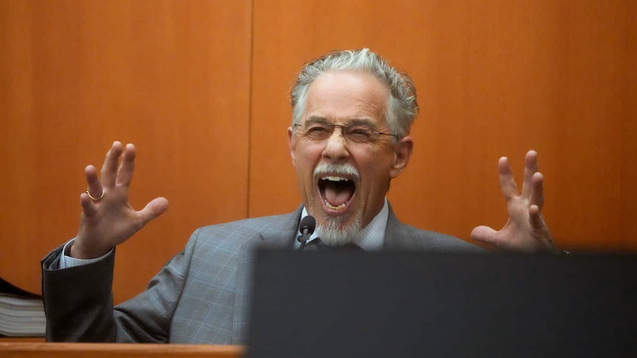 A man gesturing while he has his mouth open wide.