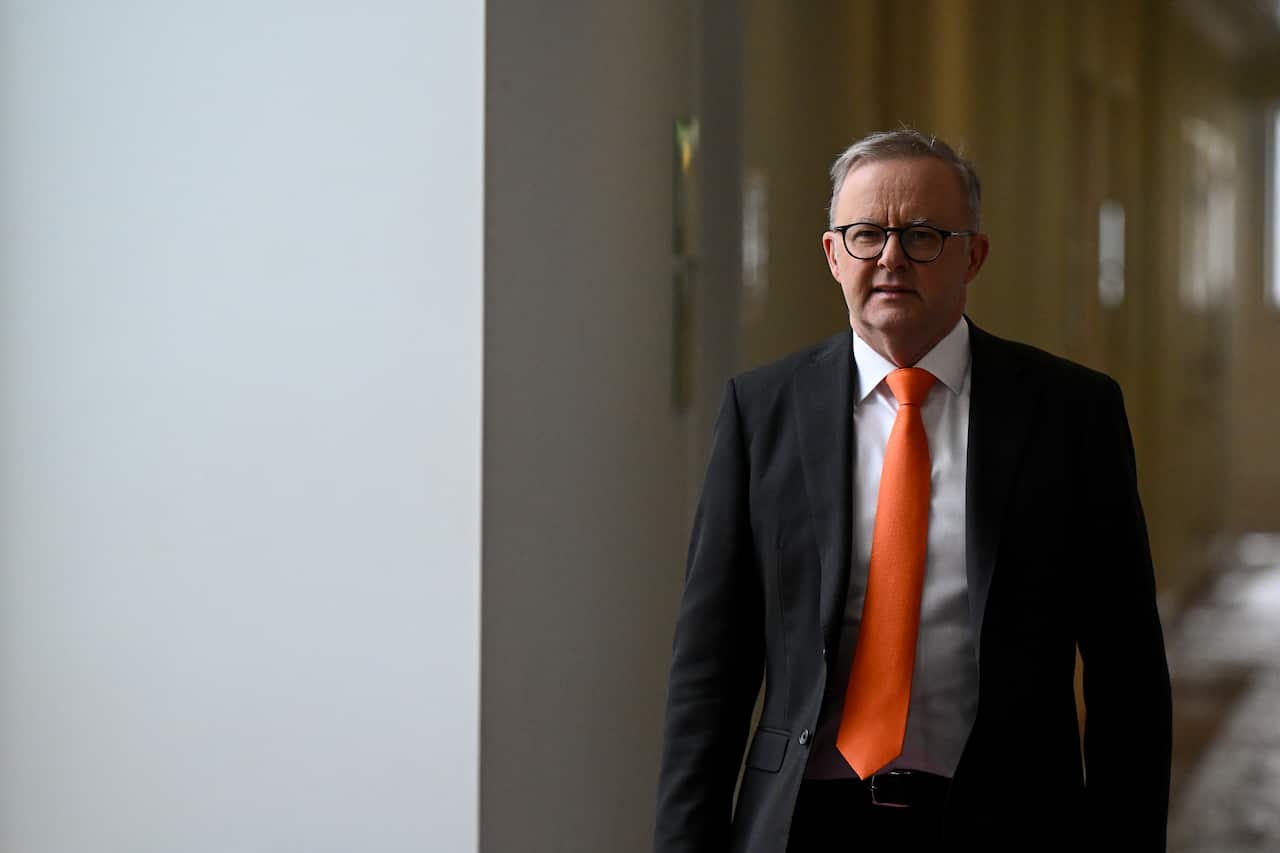 Man in suit and tie walking through a corridor.