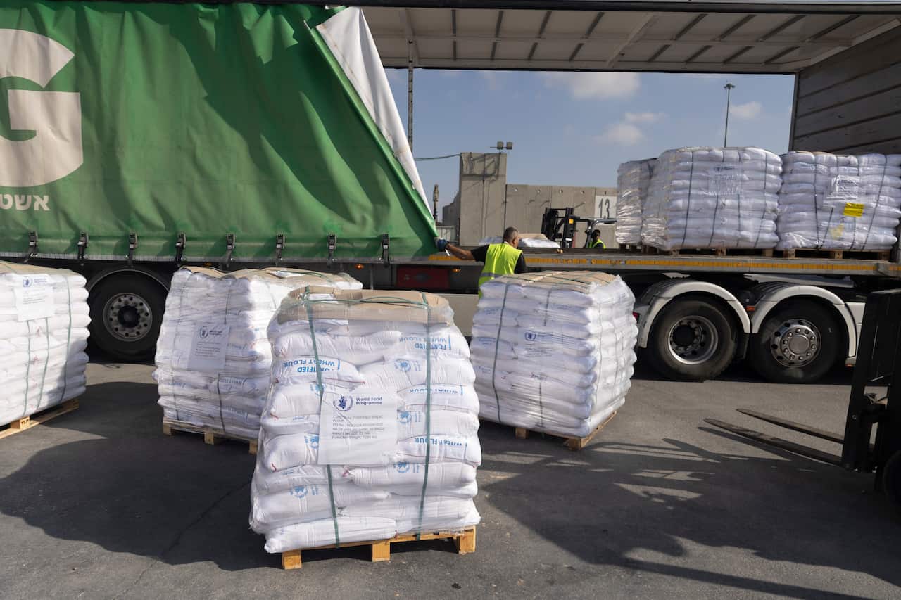 Parcels stacked on a pallett near a truck.