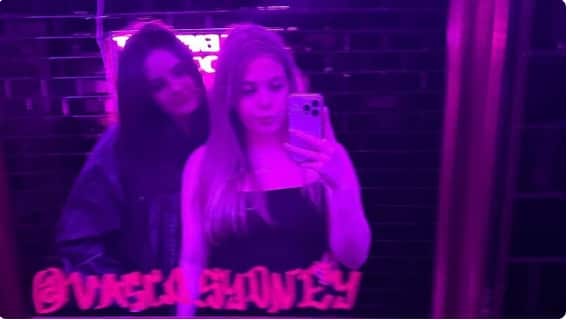 Two teenage girls taking a photo in the mirror