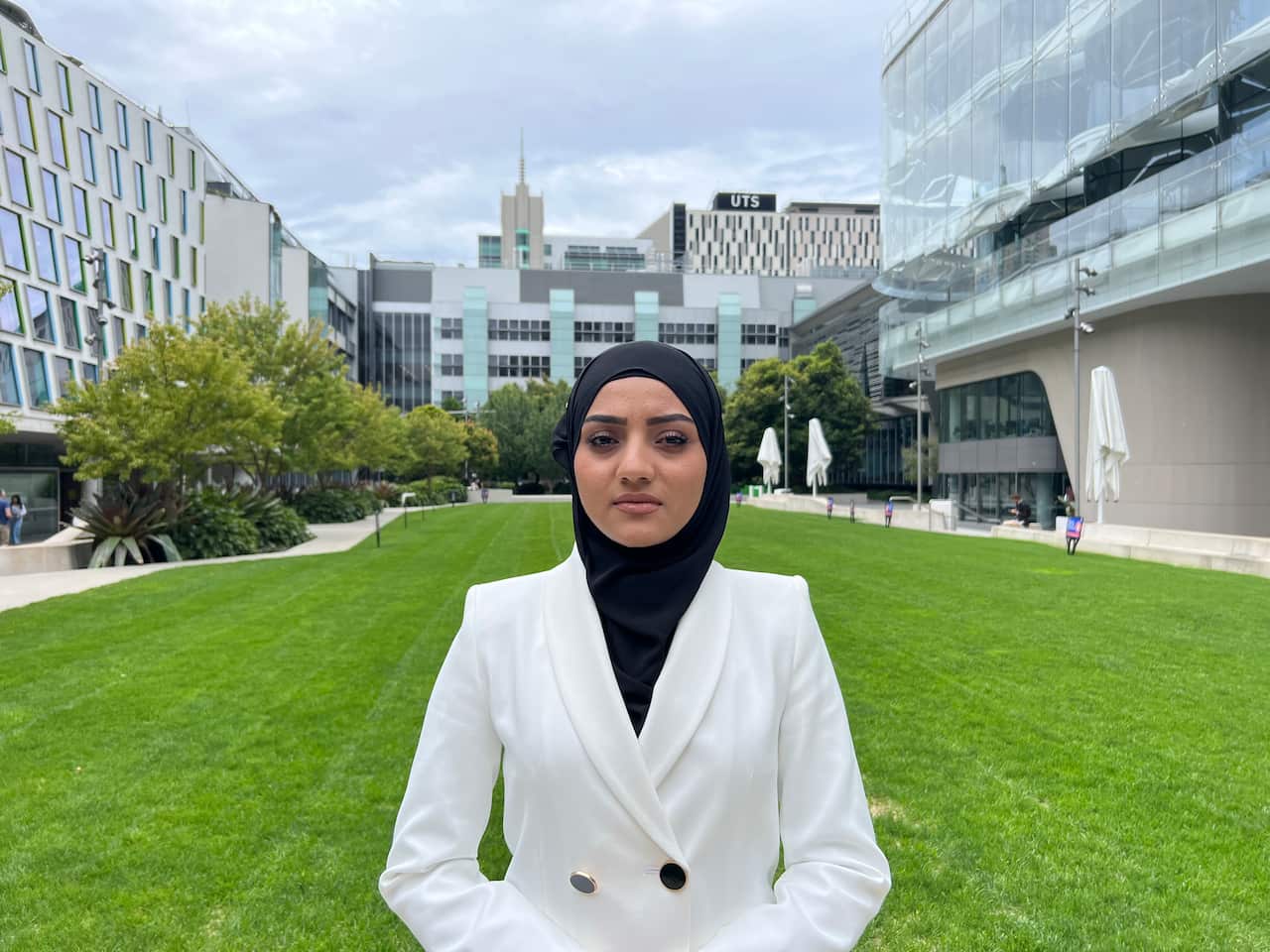 Woman wearing a white hijab stands at UTS. 