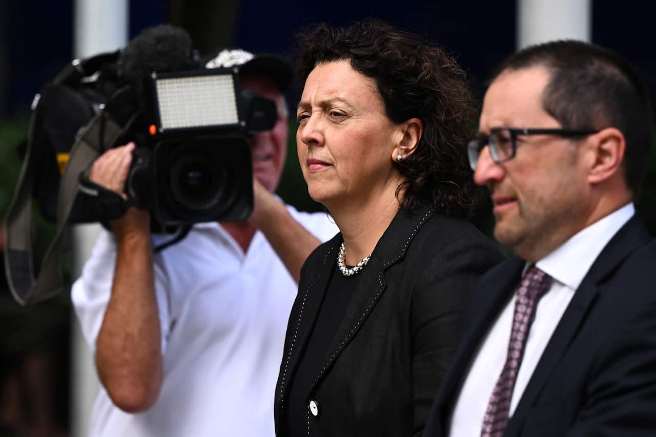 A woman leaves a court with her lawyer.