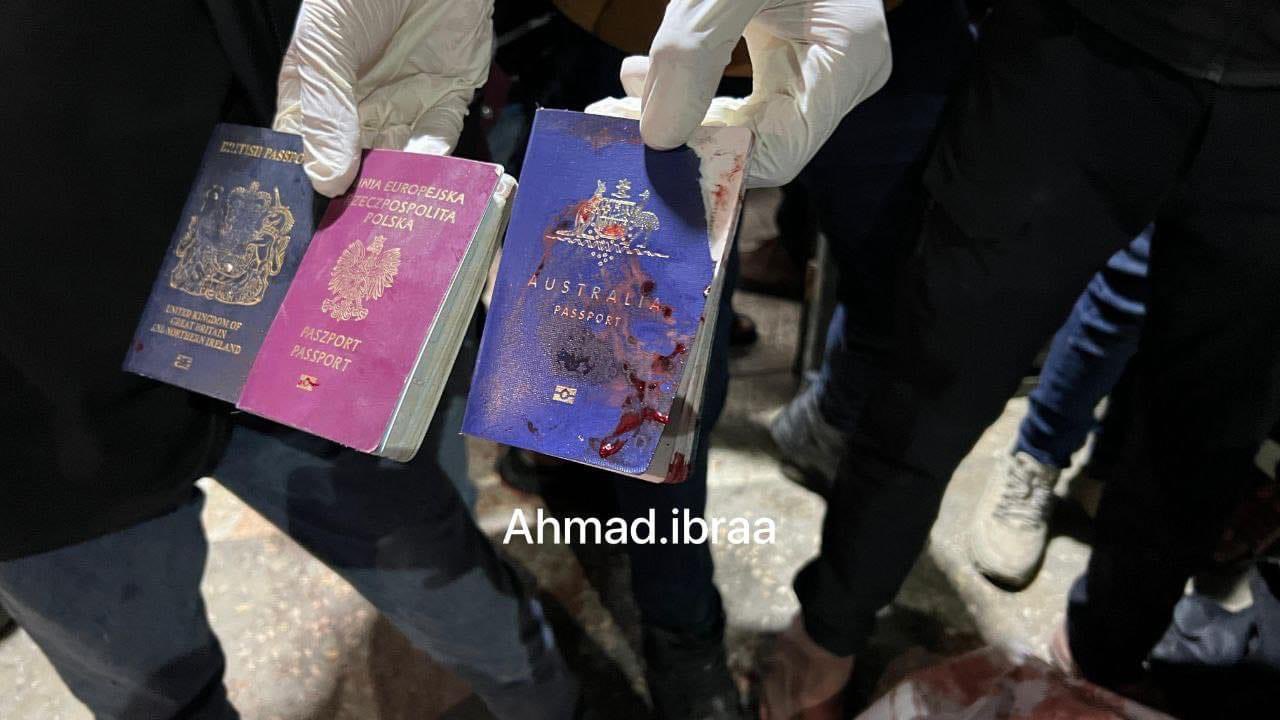A hand holding three passports
