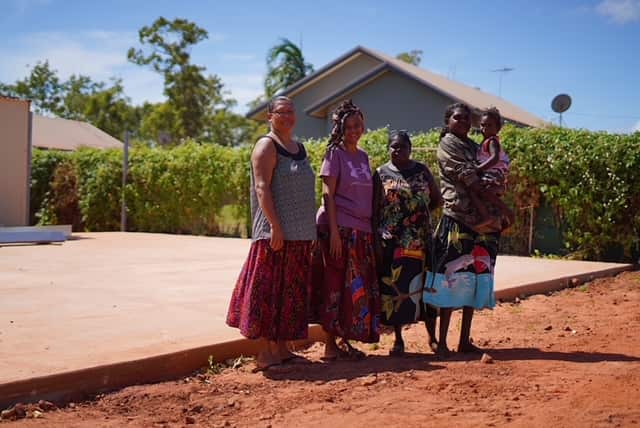 Galiwin’ku women standing in front of a concrete slab